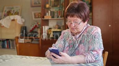 一位老年妇女在手机上写<strong>短信</strong>。 她小心翼翼地按在屏幕上，发<strong>短信</strong>。